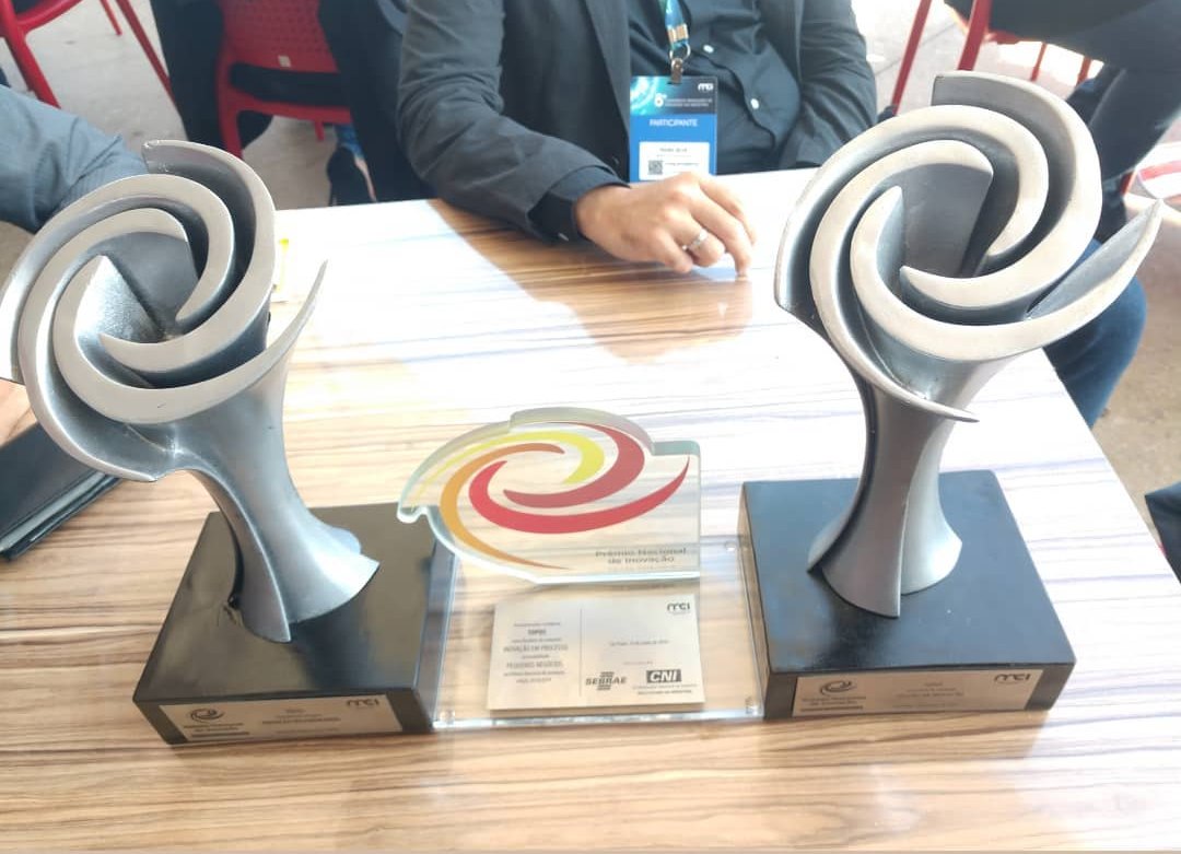 Dois troféus do Prêmio Nacional de Inovação sobre uma mesa